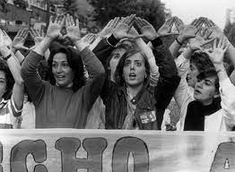 Imagen de feministas radicales con los brazos en alto haciendo un triángulo con sus manos, símbolo utilizado por el movimiento feminista para representar la unidad y la solidaridad entre las mujeres en la lucha por la igualdad de género